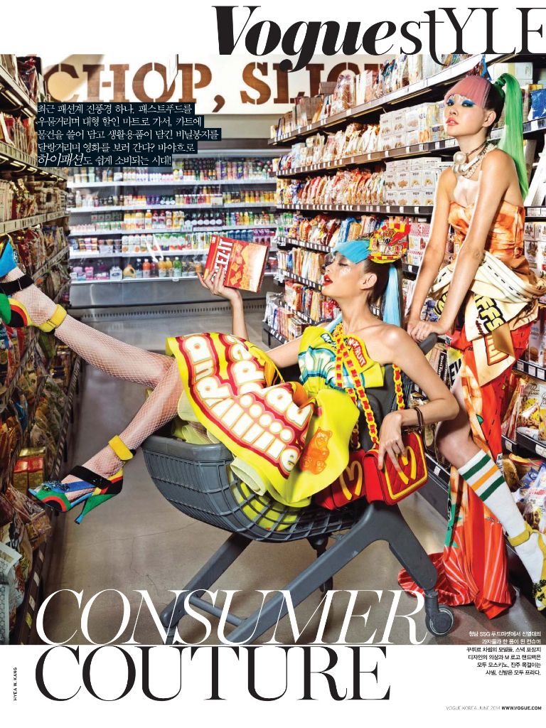 Vogue Consumer Couture — two models toppling into a shopping cart in a grocery aisle, mid-laugh
