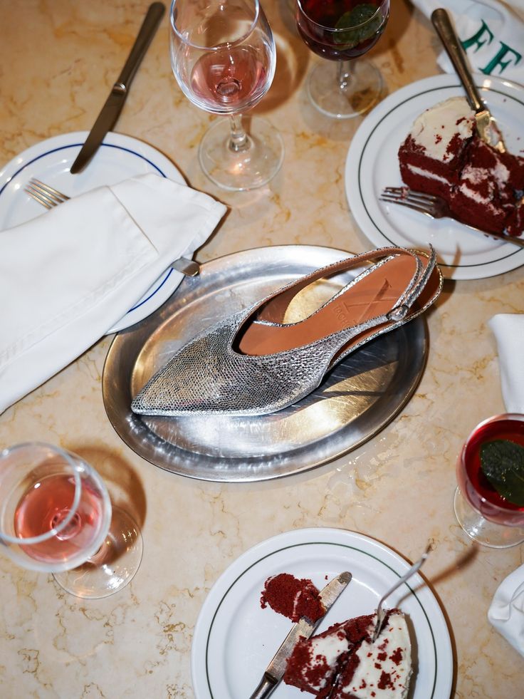 Warm restaurant ambient — silver slingback on a diner platter with red velvet cake