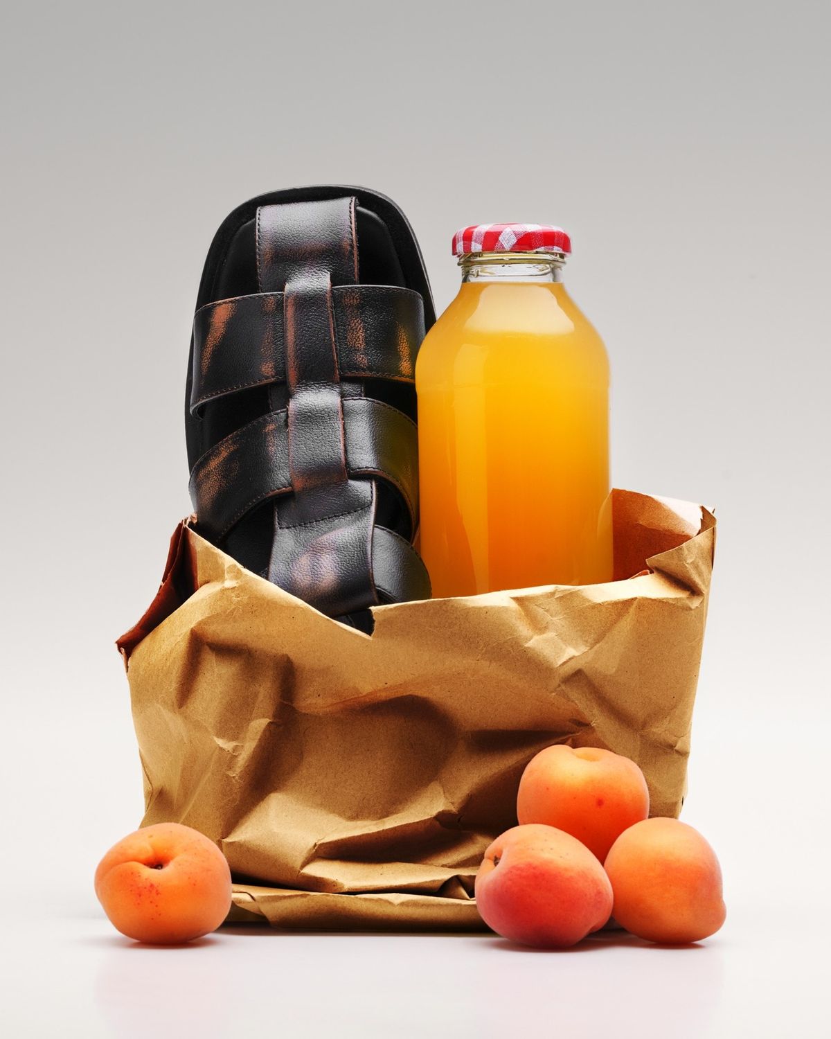 Sandal in a brown paper grocery bag — crisp studio fall-off