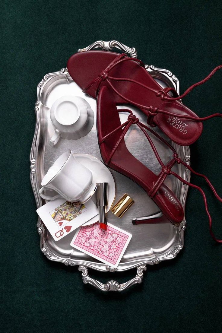 Silver tray overhead flat-lay with burgundy heels and playing cards
